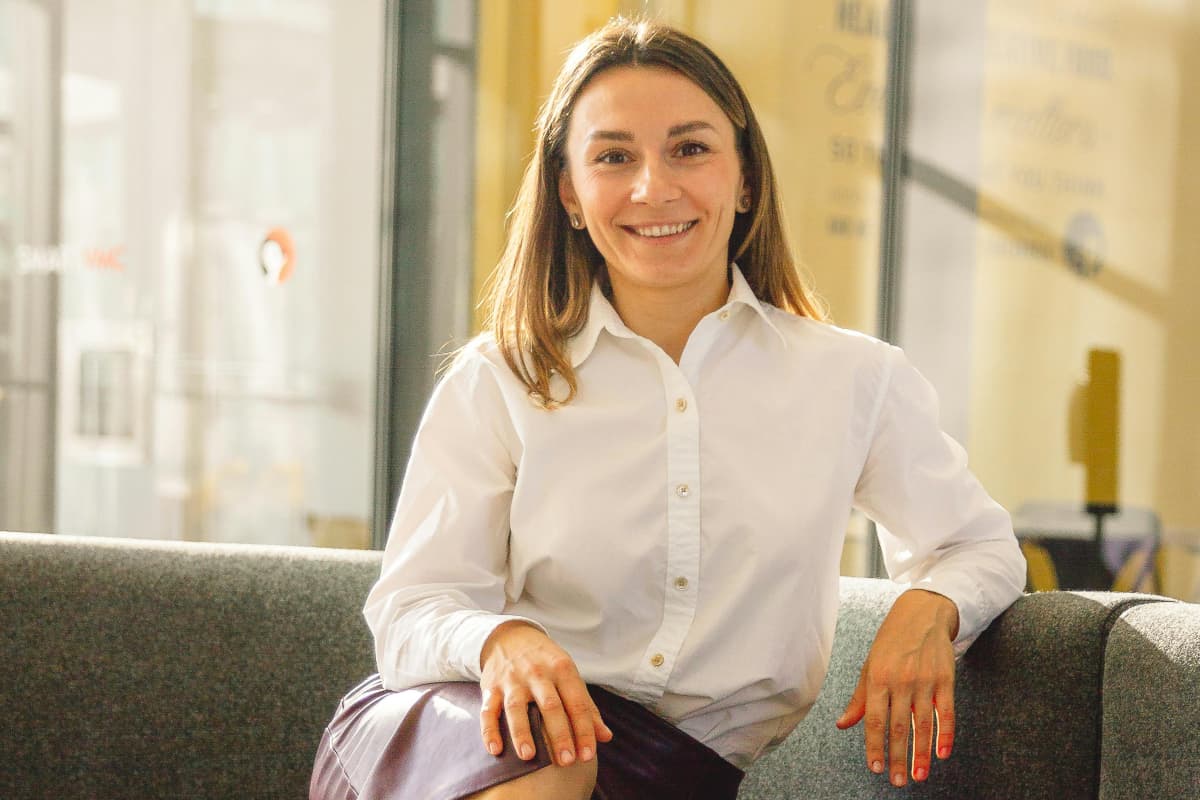 Anfitriona sentada en un sofá platicando en inglés con invitados del extranjero