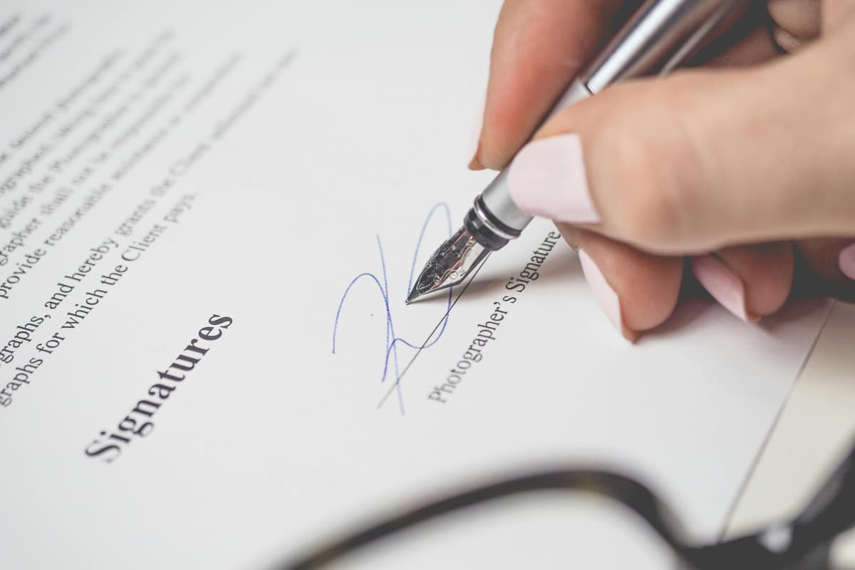 Fotógrafa profesional firmando un contrato legal por sus servicios de fotografía