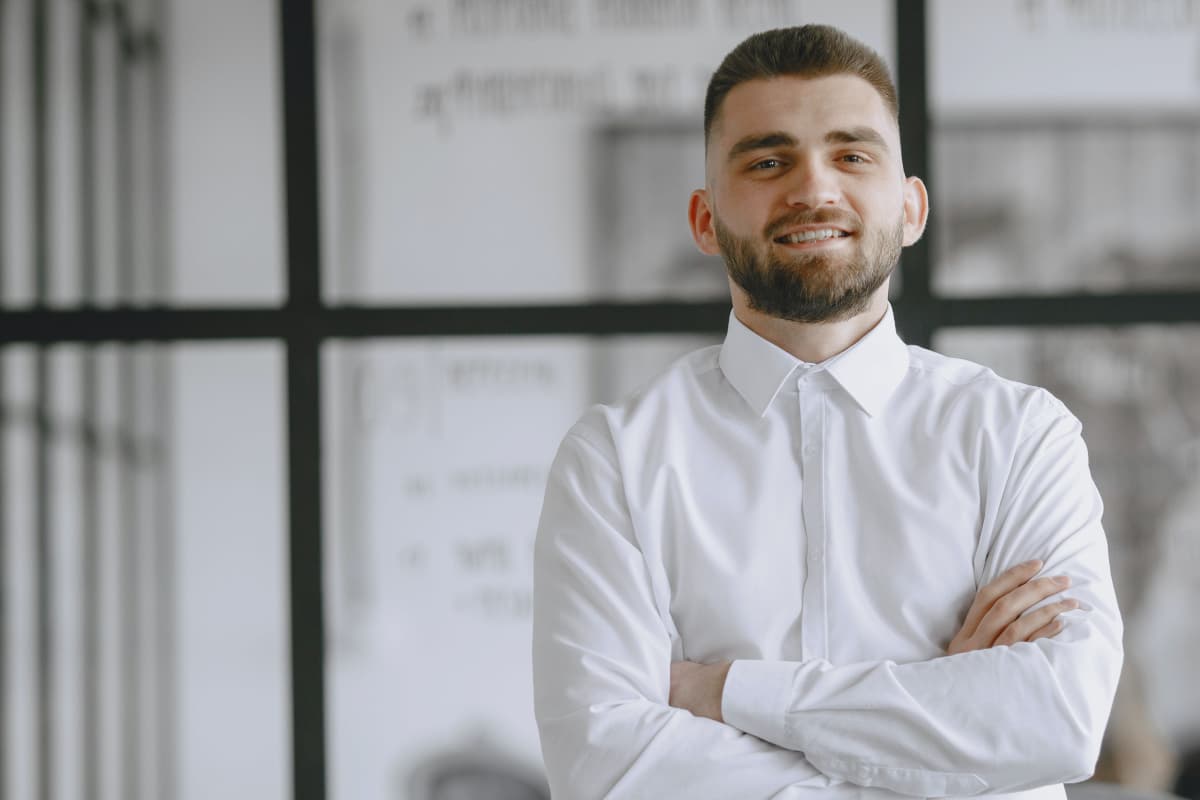 Hombre jóven formal casual en camisa blanca de manga larga en un despacho
