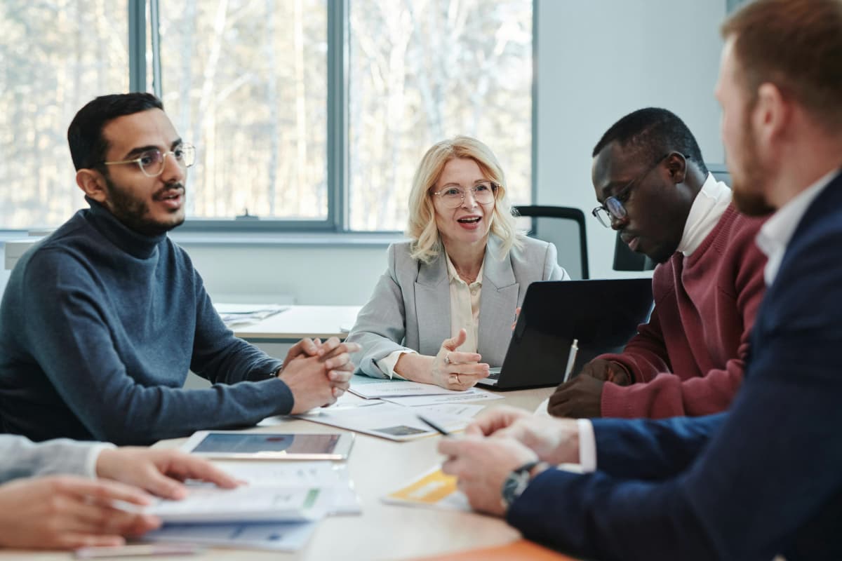 Colaboradores en una junta de negocios con clientes extranjeros negociando un proyecto importante