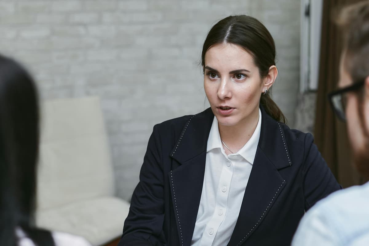 Mujer jóven conversando fluidamente en inglés con visitantes del exterior