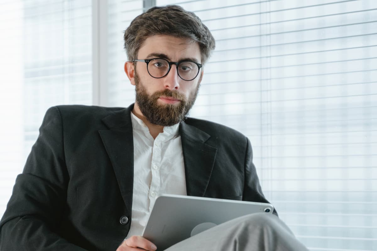 Un profesionista con lentes en su tablet revisando datos