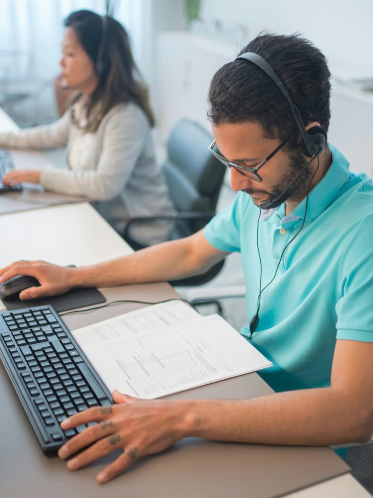 Dos profesionistas de tecnología de información en sus computadoras resolviendo problemas en sus sistemas