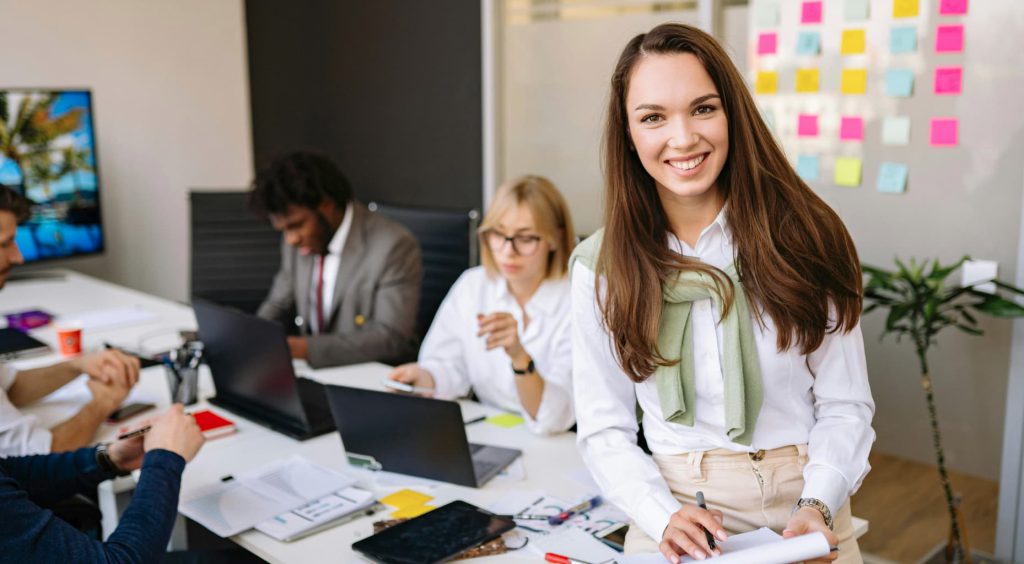 Mujer tomando notas en inglés en una junta ejecutiva